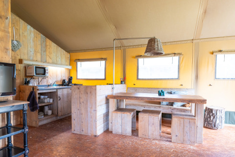 Intérieur d'une tente safari Woodlodge confortable avec meubles en bois au camping De Pampel, Veluwe, Pays-Bas.