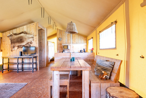 Interior of a cozy safari tent Woodlodge at Veluwe campsite De Pampel in the Netherlands with rustic decor.
