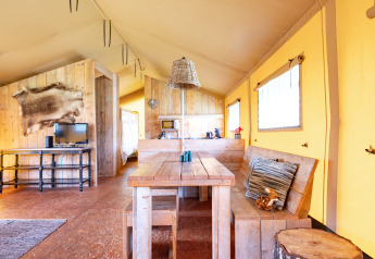 Interno di una tenda safari Woodlodge al campeggio Veluwe De Pampel nei Paesi Bassi con arredo rustico.
