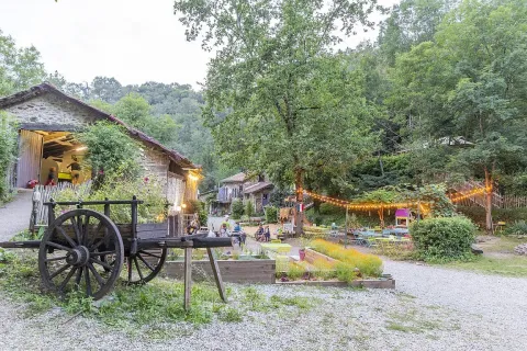 Scenic view of Campsite Moulin de Chaules in Auvergne-Rhône-Alpes, France, with lights and lush greenery.