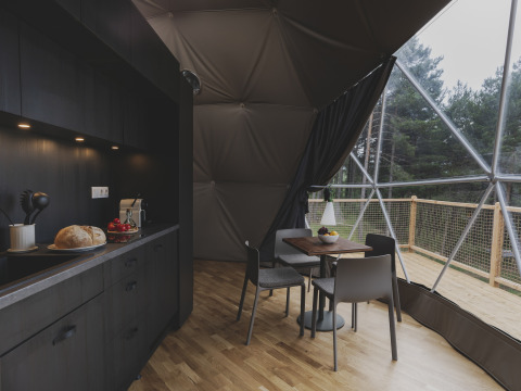 Interieur van een koepel bij Domo Family op Wecamp Pedraforca in Spanje met een moderne keuken en eethoek.
