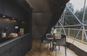 Interieur van een koepel bij Domo Family op Wecamp Pedraforca in Spanje met een moderne keuken en eethoek.