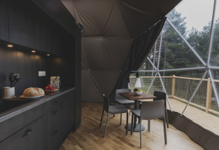 Interieur van een koepel bij Domo Family op Wecamp Pedraforca in Spanje met een moderne keuken en eethoek.