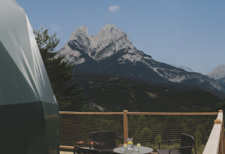 Uitzicht vanaf de Domo Family-koepel bij Wecamp Pedraforca in Spanje, met terras, bergen en stoelen.
