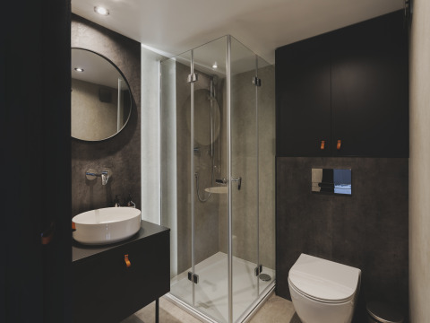 Moderne badkamer bij Domo Family van Wecamp Pedraforca met glazen douche, wandtoilet en ronde spiegel.