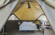 Interieur van een Bell Tent safaritent met tweepersoonsbed en moderne voorzieningen bij Wecamp Pedraforca.