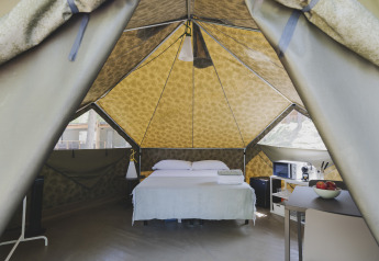 Interior de una tienda safari Bell Tent con cama doble y comodidades modernas en Wecamp Pedraforca, España.