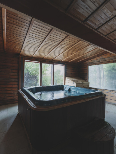 Binnenbubbelbad in een houten hut bij Wecamp Pedraforca vakantiepark in Catalonië, Spanje met grote ramen.