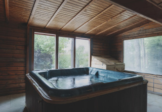 Binnenbubbelbad in een houten hut bij Wecamp Pedraforca vakantiepark in Catalonië, Spanje met grote ramen.