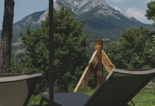 Uitzicht op de Pedraforca-berg vanuit ligstoelen onder een parasol bij Wecamp Pedraforca, Catalonië, Spanje.