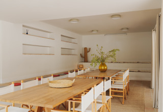 Moderner Essbereich im Wecamp Cabo de Gata in Andalusien, Spanien, mit Holzstühlen und minimalistischer Deko.