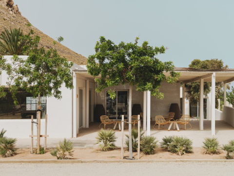 Outdoor terrace at Wecamp Cabo de Gata holiday park in Andalusia, Spain, with trees and mountain scenery.