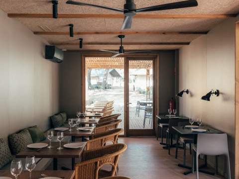 Indoor dining area at Wecamp Cádiz holiday park in Andalusia, Spain, featuring wooden tables and cozy seating.