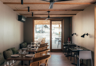 Comedor interior en Wecamp Cádiz, un parque vacacional en Andalucía, España, con mesas de madera y sillas cómodas.