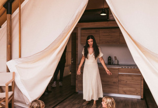 Madre e bambini giocano davanti a una tenda al Wecamp Cadaqués, villaggio turistico in Catalogna, Spagna.