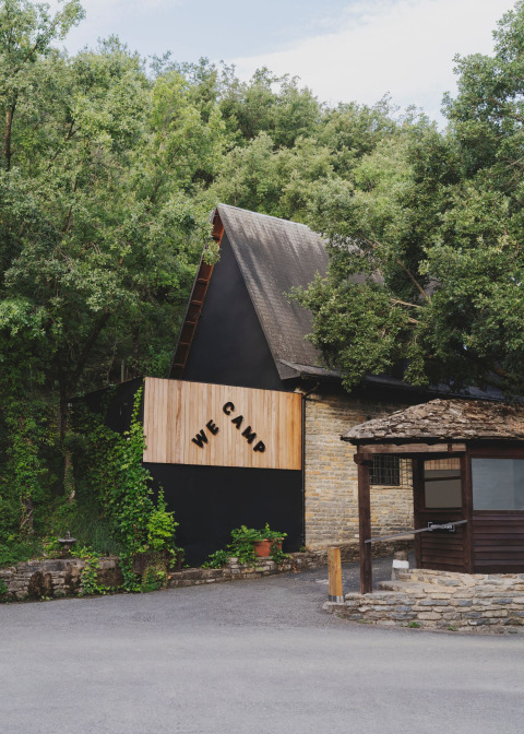Edificio de tejado inclinado en la entrada de Wecamp Pirineos, un parque vacacional en Aragón, España.