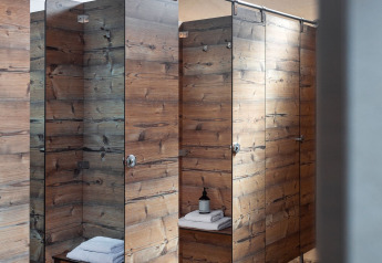 Cabines de douche en bois moderne avec sol carrelé dans la Bell Tent à Wecamp Pirineos, Espagne.