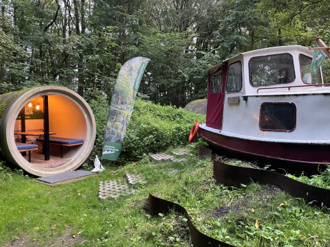 Unique forest lodge with a boat and pipe-shaped cabin at Cabin Boat, Buytenplaets Suydersee, Netherlands.