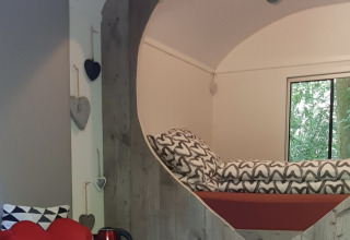 Innenansicht des Tiny Houses Pipo Love mit herzförmigem Bett und gemütlicher Dekoration in den Niederlanden.