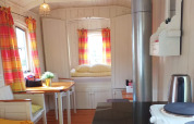 Gemütlicher Innenraum des Tiny House Pipo Wagon mit gelben und roten Vorhängen in den Niederlanden.