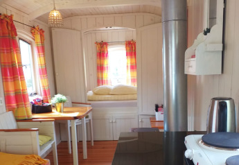 Interno accogliente della tiny house Pipo Wagon con tende colorate a Buytenplaets Suydersee, Paesi Bassi.