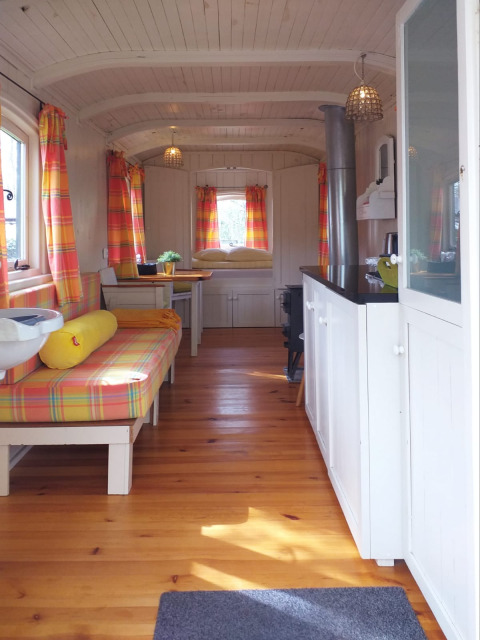 Interior of the tiny house Pipo Wagon at Buytenplaets Suydersee in the Netherlands with colorful curtains.