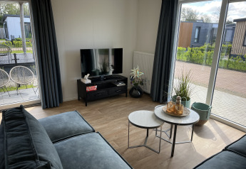Living room at Sea bass chalet in Holiday Park de Zeeuwse Parel, Netherlands, with modern interior and sunlight.