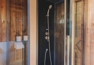 Moderne douchecabine in een safaritent op Wecamp L'Escala Punta Mila, Spanje, met houten afwerking.