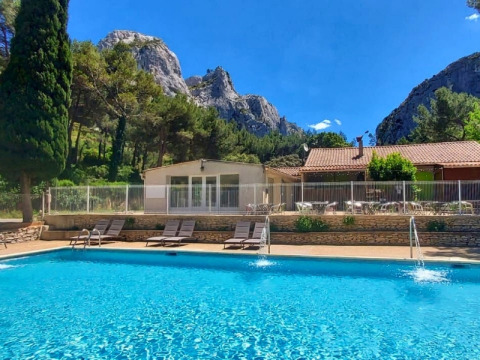 Piscina con lettini al campeggio La Vallée Heureuse, tra le montagne della regione Provenza-Alpi-Costa Azzurra.