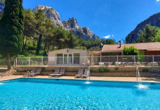 Piscina con lettini al campeggio La Vallée Heureuse, tra le montagne della regione Provenza-Alpi-Costa Azzurra.