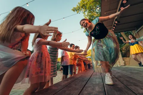 Enfants et adultes déguisés s’amusent sur scène au Vallicella Glamping Resort en Toscane, Italie.