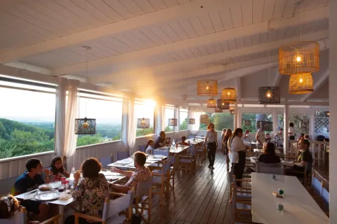 Restaurant en plein air au coucher du soleil avec vue champêtre au Vallicella Glamping Resort en Toscane.