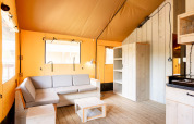 Interior view of the safari tent 'Nomad' at Campsite Le Moulin de Bel Air in France with furnishings.