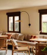 Gezellige lounge in Wecamp Cudillero, Asturië, Spanje, met houten stoelen en lichte stoffen kussens.