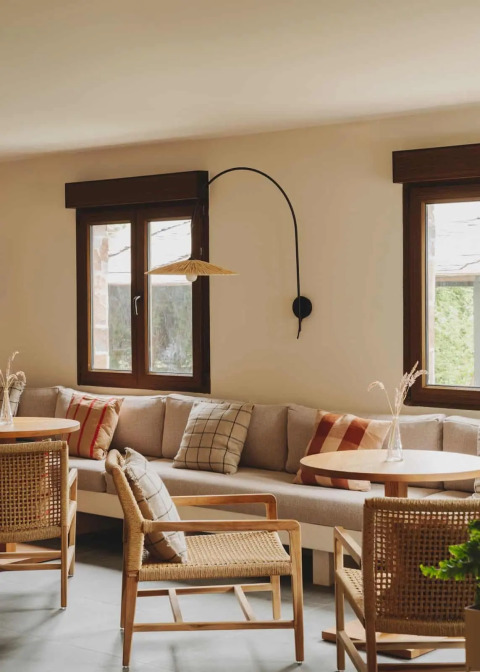 Gemütlicher Loungebereich im Wecamp Cudillero, Asturias, Spanien, mit Sitzbank, Holz- und Korbmöbeln.