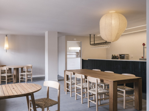 Modernes Café-Innere im Wecamp Cudillero, Asturien, mit Holzmöbeln, Bar und stilvoller Beleuchtung.
