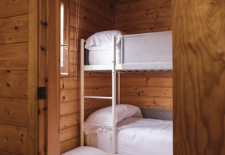 Habitación con literas y paneles de madera en Bungalow Basic Family Plus de Wecamp Cudillero, España.