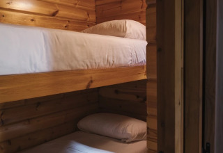 Litera con dos camas individuales en una tiny house de madera en Wecamp Cudillero, España.