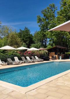 Swimmingpool auf dem Campingplatz Pagel in Okzitanien, Frankreich, mit Liegen und Sonnenschirmen.