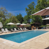 Outdoor pool at Campsite Pagel in Occitanie, France, with deck chairs and umbrellas under blue sky.