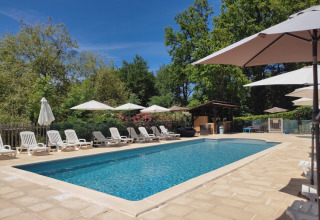 Swimmingpool auf dem Campingplatz Pagel in Okzitanien, Frankreich, mit Liegen und Sonnenschirmen.