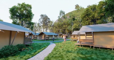 A glamping site with modern tent cabins, a gravel path, lush greenery, and people enjoying the outdoors.