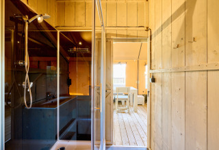 Interior view of a Ranger safari tent at Spina Family Collection campsite in Italy, showing shower and dining area.