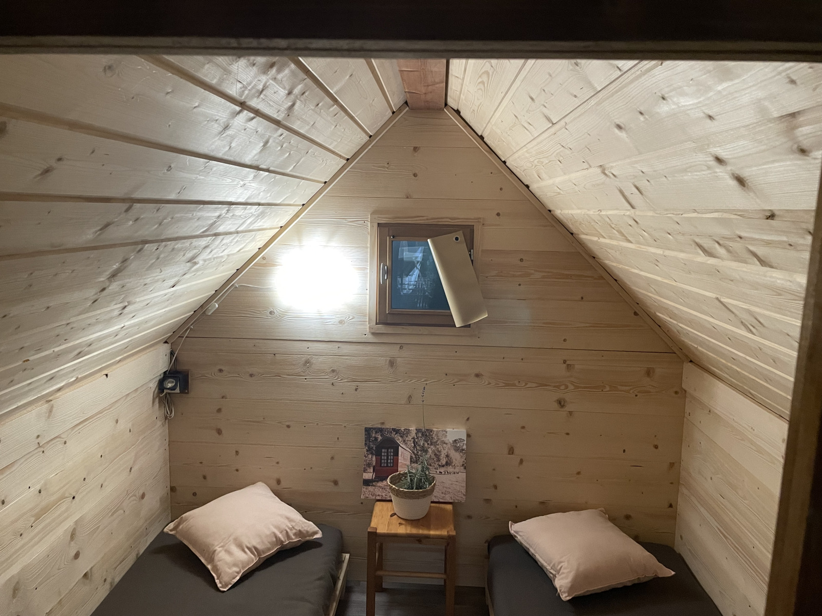 Knusse kamer met twee eenpersoonsbedden, houten wanden en raam, in een Franse safaritent.