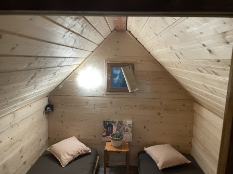 Knusse kamer met twee eenpersoonsbedden, houten wanden en raam, in een Franse safaritent.