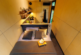 Compacte, moderne lodge met knus bed en keuken bij River Mirrorlodge, Holiday park Mölke, Nederland.