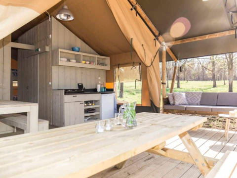 Interior view of the Bergerac Deluxe safari lodge tent at La Draille, France, featuring a kitchen and lounge area.