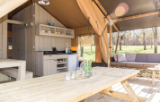 Vue intérieure du lodge tente safari Bergerac Deluxe à La Draille en France avec cuisine et salon extérieur.