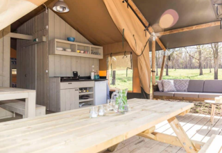 Indvendig udsigt over safari Lodge teltet Bergerac Deluxe på La Draille i Frankrig med spise- og opholdsområde.