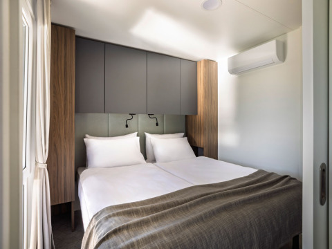 Slaapkamer met twee enkele bedden en een modern interieur in een Premium Holiday Home bij Aminess Planet Camping Sirena, Kroatië.